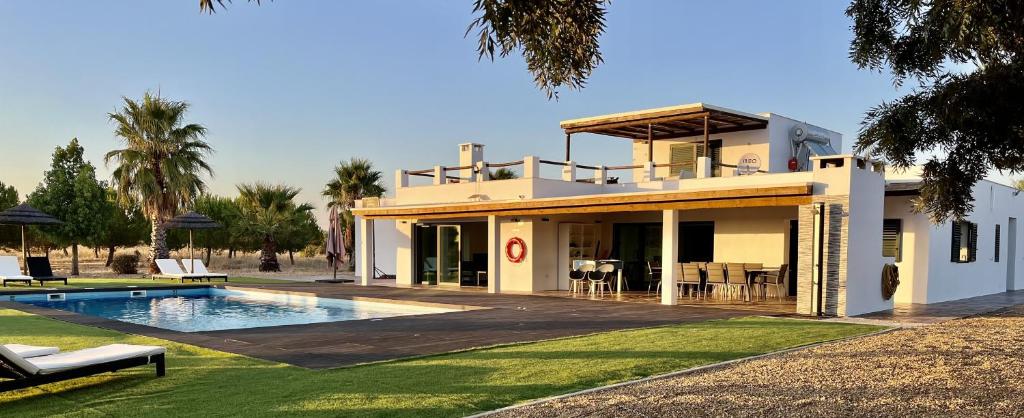 a house with a swimming pool in front of it at Monte da Figueira Brava in Aldeia dos Ruins