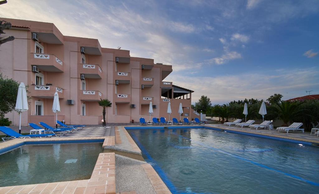 un hôtel avec une piscine en face d'un bâtiment dans l'établissement Hotel Stefani, à Sarti