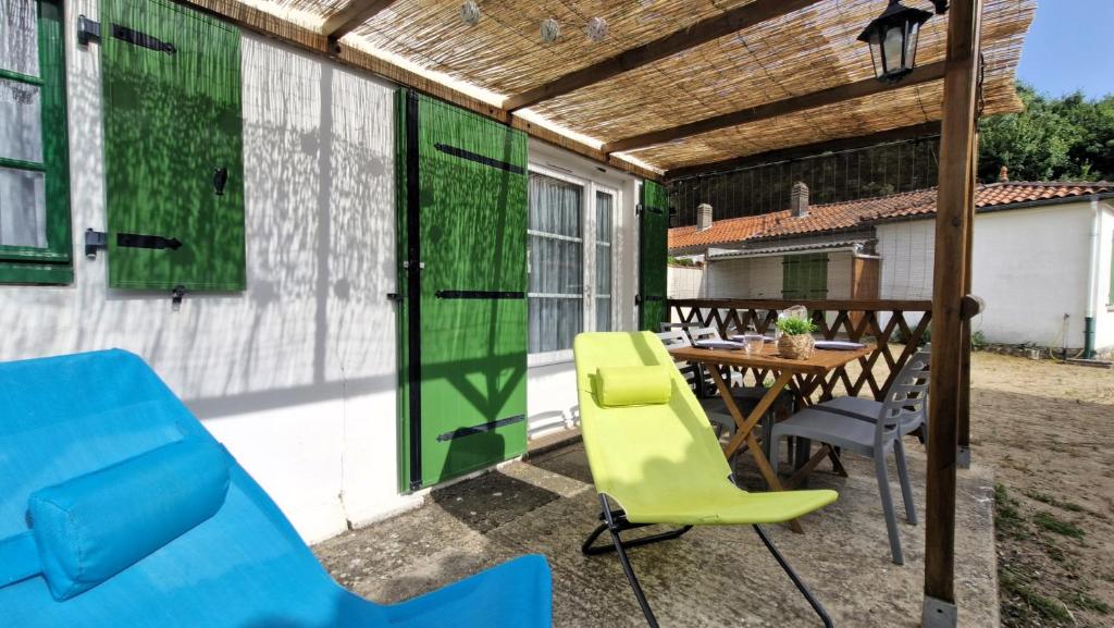 un patio avec une table et des chaises en bois dans l'établissement St Georges de Didonne - AGREABLE PETITE MAISON avec COUR - 1 Chambre, à Saint-Georges-de-Didonne