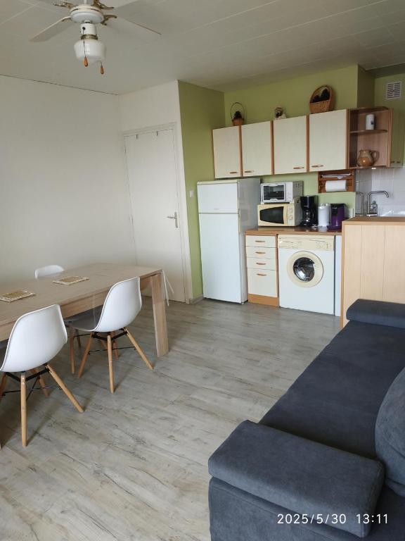 une cuisine et un salon avec une table et des chaises dans l'établissement Appartement - 4 personnes - Saint-Hilaire-de-Riez, à Saint-Hilaire-de-Riez