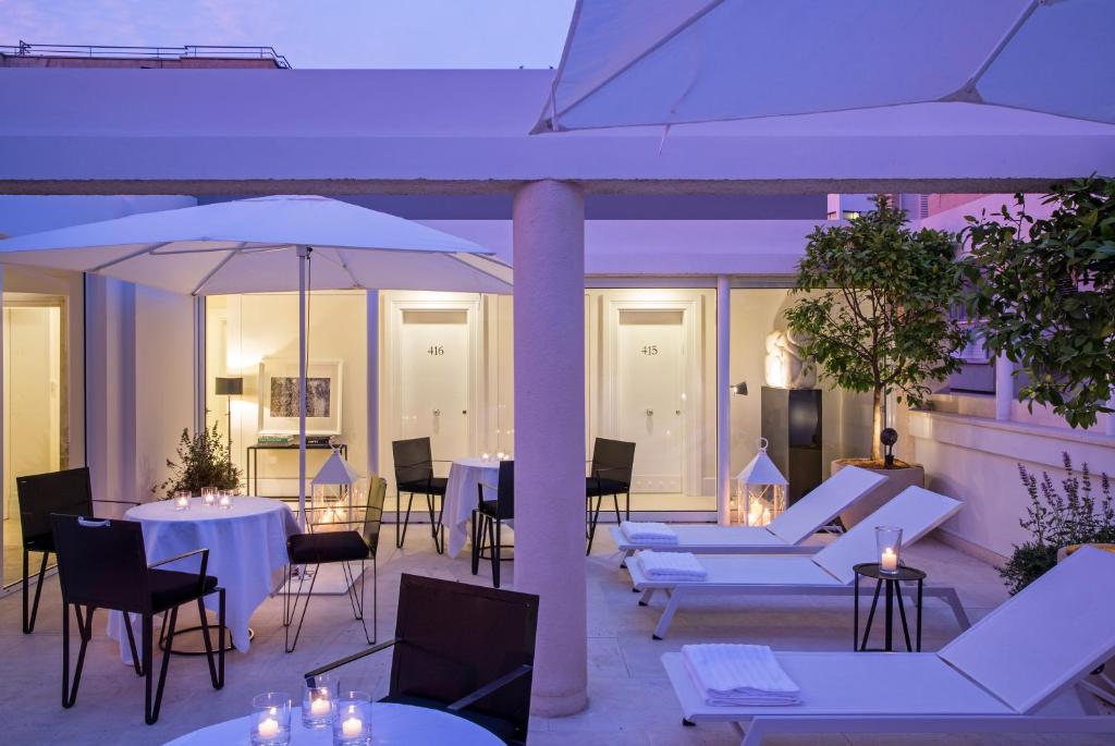 a dining room table with chairs and umbrellas at White Villa Tel Aviv Hotel in Tel Aviv