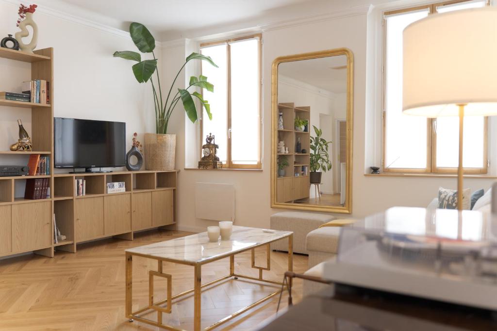- un salon avec une table et un miroir dans l'établissement Appartement Villa Toki-Ona, à Antibes