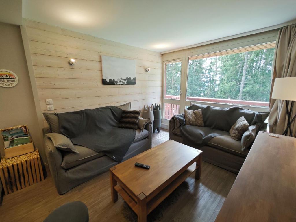 un salon avec deux canapés et une table basse dans l'établissement Appart 8 Personnes avec Salon Neuf et Parking Couvert Le Thuria, à Bourg-Saint-Maurice