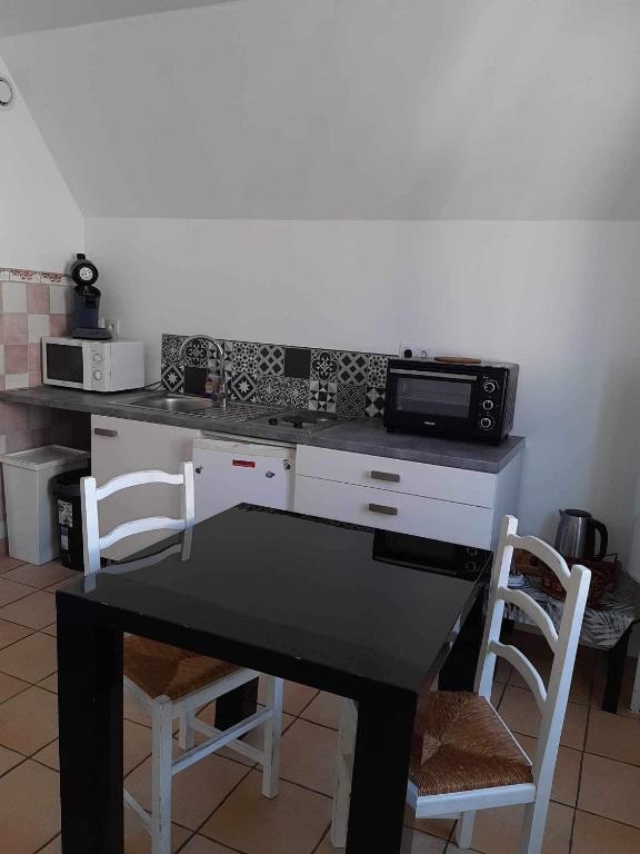 une cuisine avec une table noire et un four micro-ondes dans l'établissement Sea and Sun 3, à Berck-sur-Mer