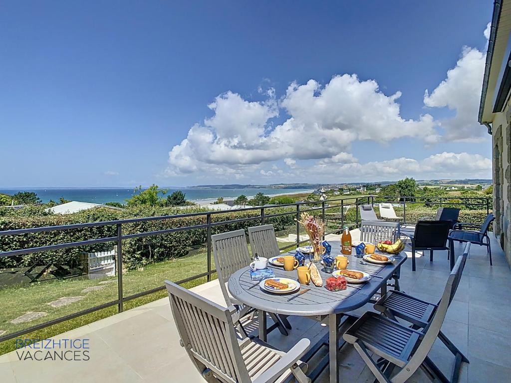 une table avec de la nourriture dessus sur un balcon dans l'établissement Maison de Porz Iroise (Vue Mer), à Plomodiern