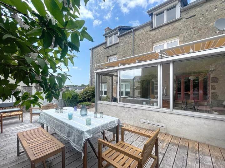 un patio avec une table et des chaises et un bâtiment dans l'établissement Le patio des moussaillons, à Blainville-sur-Mer