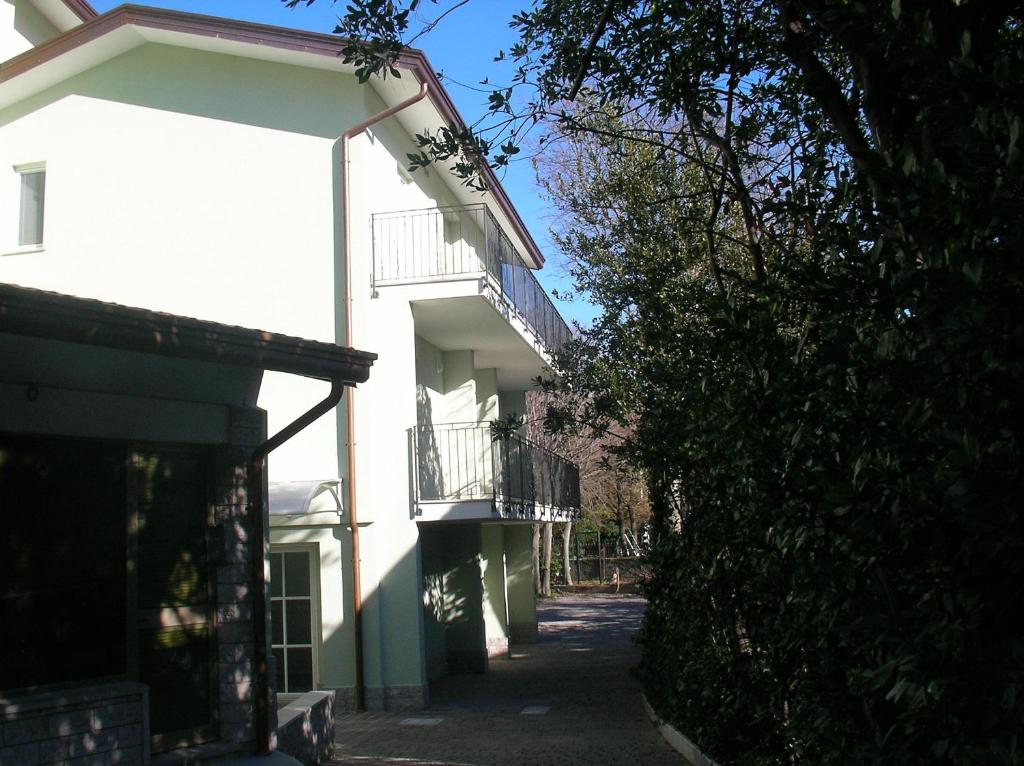 a white building with a balcony on a street at Residence Villa Susy in Duino