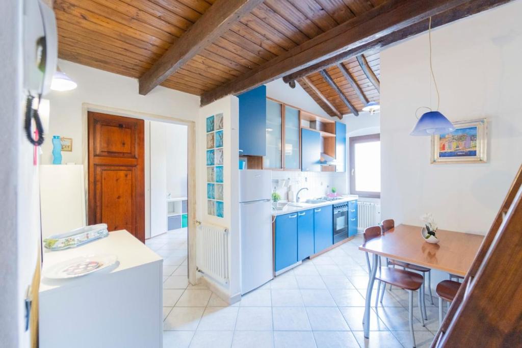 a kitchen with blue cabinets and a wooden ceiling at Casa tipica ligure lungomare in pieno centro in Lerici