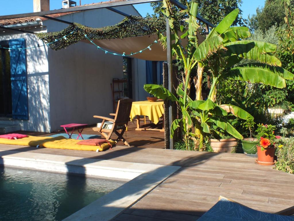 une arrière-cour avec une piscine, une table et quelques plantes dans l'établissement maison tranquille en Provence, à La Celle-sous-Gouzon