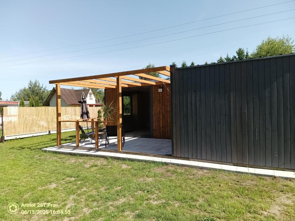 a small house with a black exterior at Domek letniskowy Osieki Parkowa in Osieki
