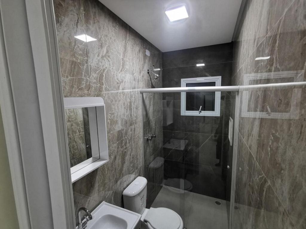 a bathroom with a shower and a toilet and a sink at Apartamento 04 Centro de Igrejinha in Igrejinha