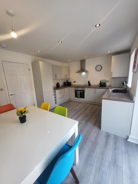 eine Küche mit einem weißen Tisch und Stühlen in der Unterkunft Bright & Spacious 3-Bed Rotherham Home Ideal for Families or Contractors in Kimberworth