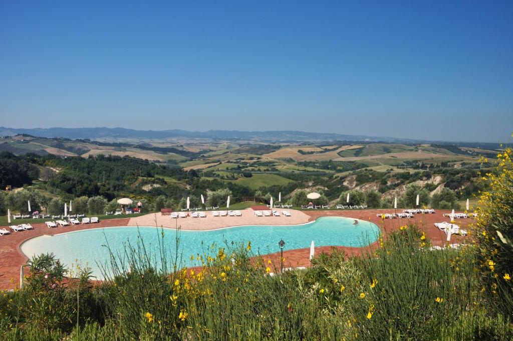vistas a una piscina con sillas y mesas en Agriturismo eco-bio Belmonte Vacanze, en Montaione