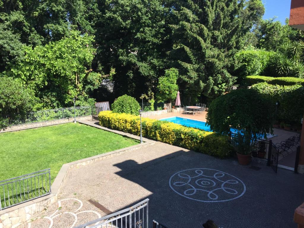 un cortile con piscina e giardino di B&B Le Querce a Formello