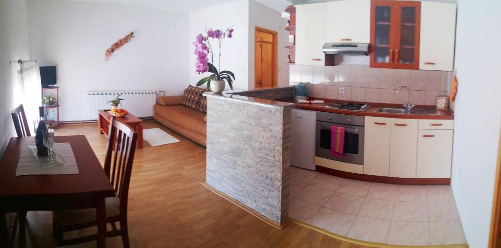 a kitchen and a living room with a counter and a table at Guest House Domig in Ličko Lešće