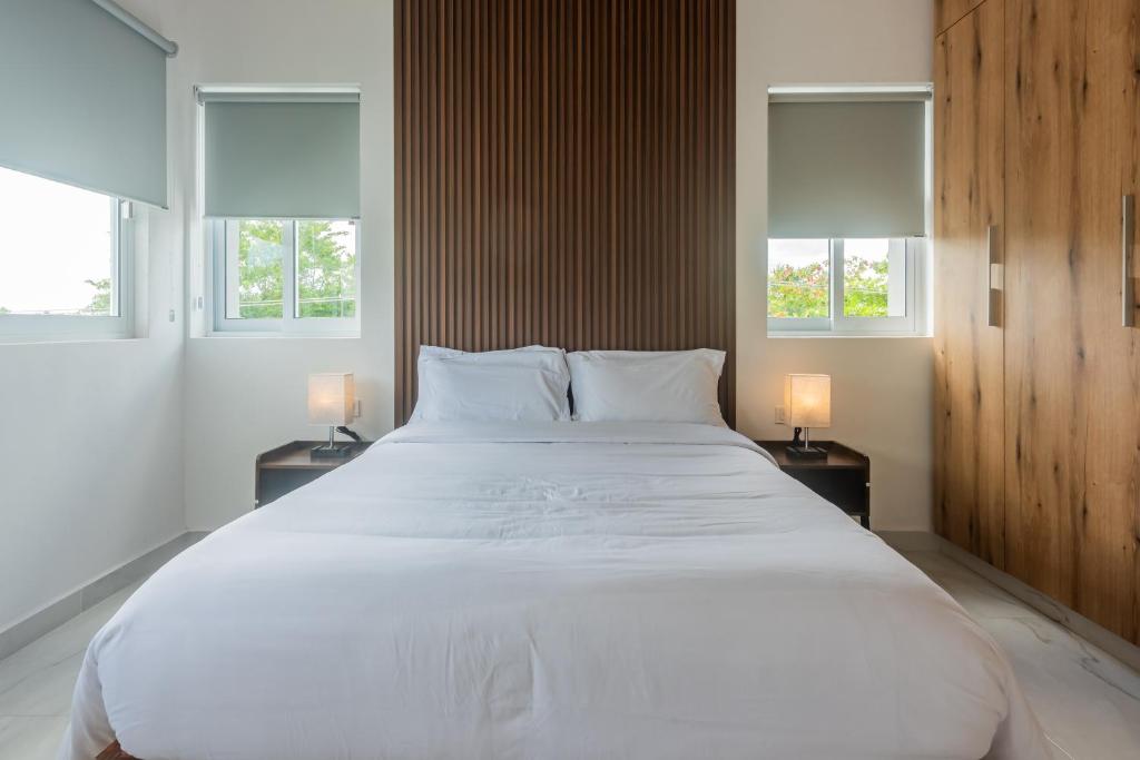 1 cama blanca grande en una habitación con ventanas en Malibu Residential 3BD Shalva, en Cozumel
