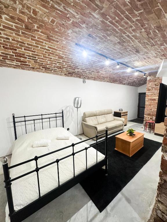 a bedroom with a bed and a brick wall at Wagner's Refuge 1 in Riga