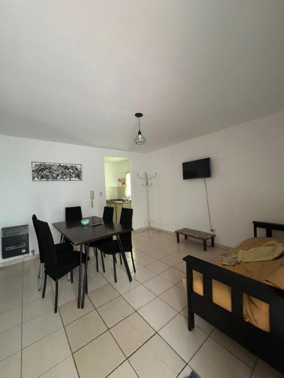 a living room with a table and chairs and a television at Alem 21 in Villa María