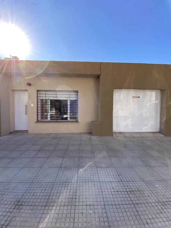 a garage with two white doors and a window at N&G Alquiler Temporal in Venado Tuerto