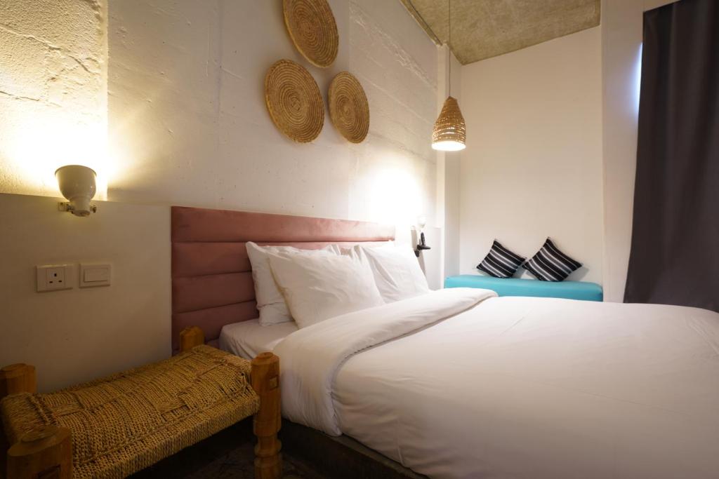 a bedroom with a large white bed and a bench at Dara Al Yammamah Hotel in Jeddah