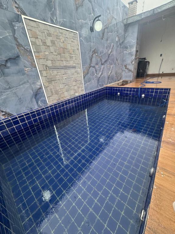 ein großer Swimmingpool mit blauen Fliesen in einem Badezimmer in der Unterkunft Moderno 3 quartos piscina e sinuca luxo in Campina Grande