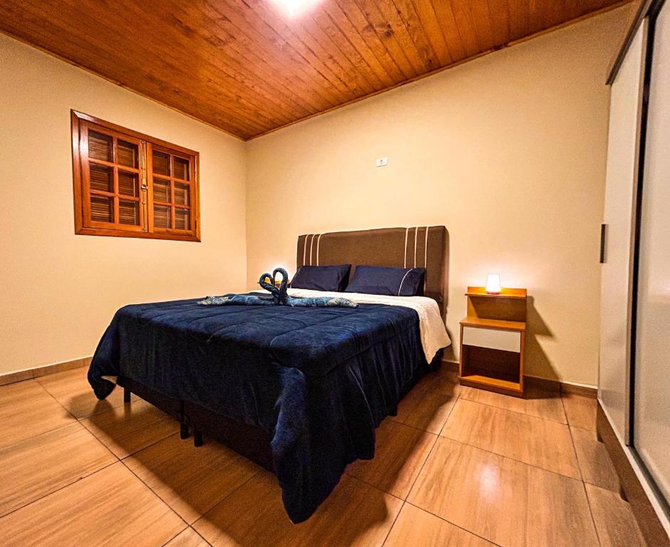 a bedroom with a bed and a wooden ceiling at Hospedaria MonteNegro in Campos do Jordão