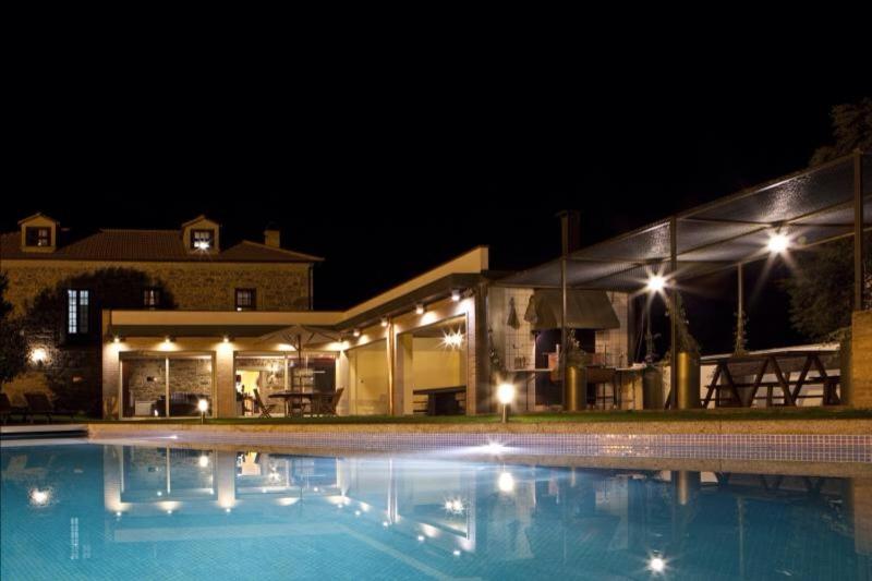 Una piscina frente a un edificio por la noche. en Quinta da Devesa, en Valença