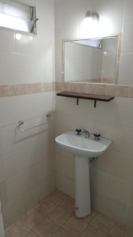 un bagno bianco con lavandino e specchio di CASONA Malva del Rio a Villa Carlos Paz