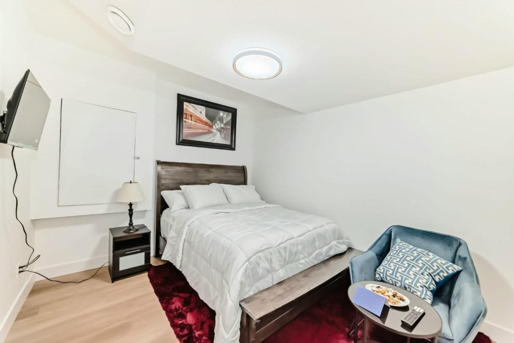 une chambre blanche avec un lit et une chaise dans l'établissement Ola's Place, à Edmonton