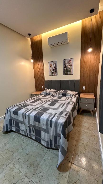a bedroom with a bed with a blue and white blanket at Casinha da Ana in Bacabal
