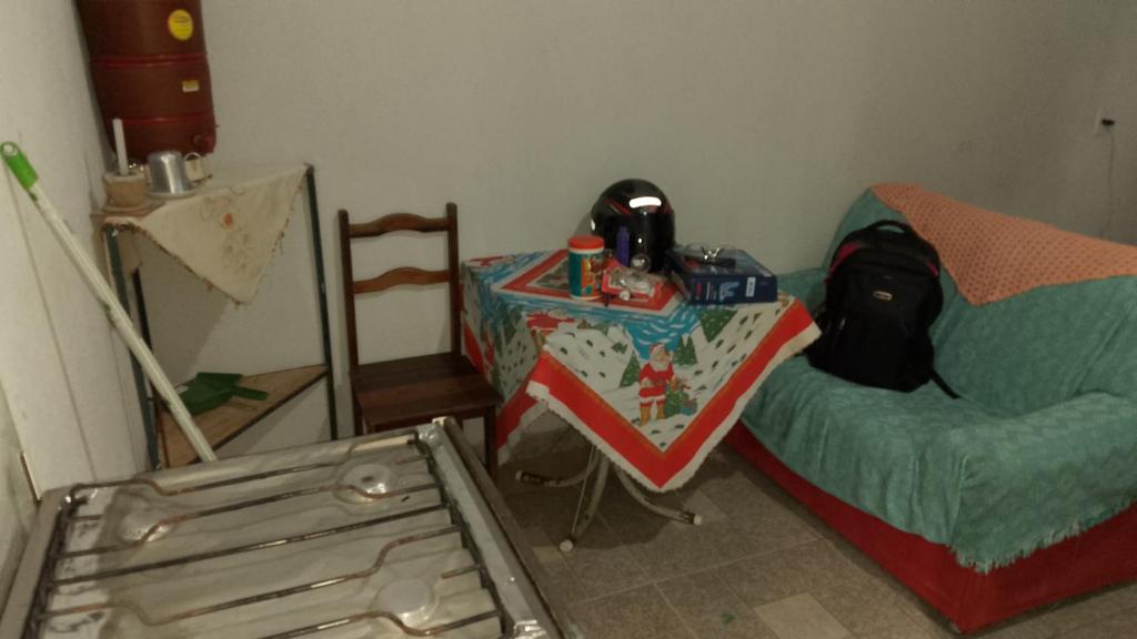 a room with a table and a bed and a chair at Casa Canela in Cavalcante