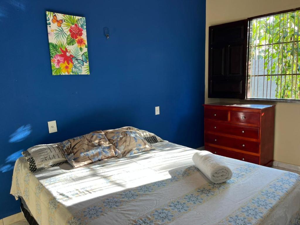 a bedroom with a bed and a blue wall at Recanto da Vovó in Santarém
