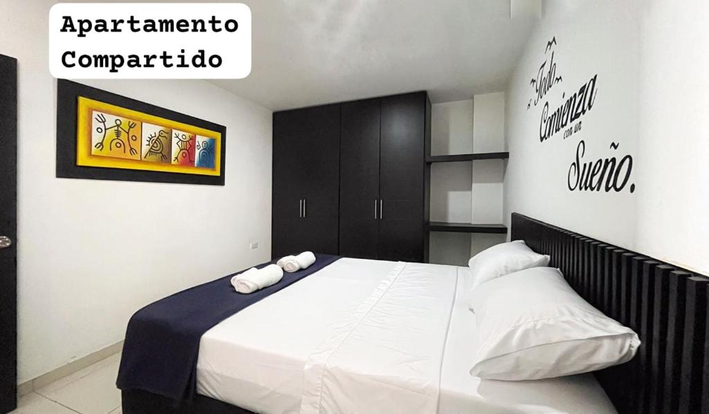 a bedroom with a bed with white sheets and pillows at Apartahotel La Terraza - San Gil in San Gil