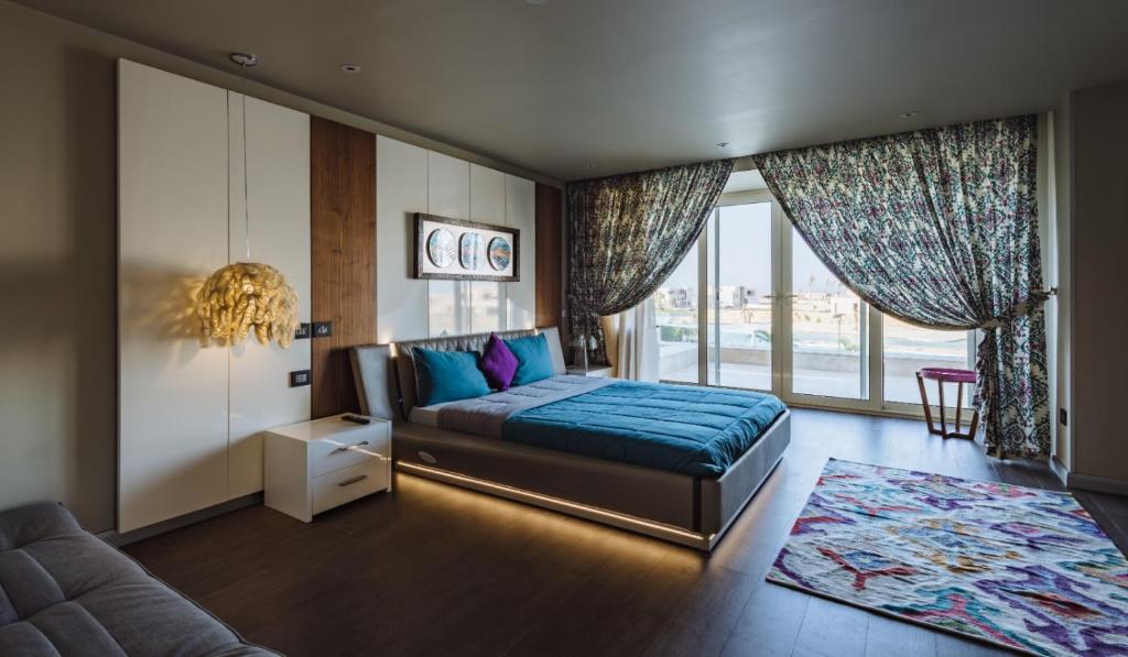 a bedroom with a bed and a large window at الساحل الشمالي in El Alamein