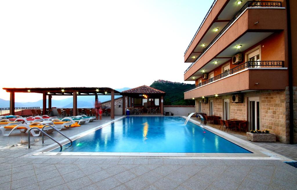 een zwembad aan de zijkant van een gebouw bij Apartments Grand in Sveti Stefan