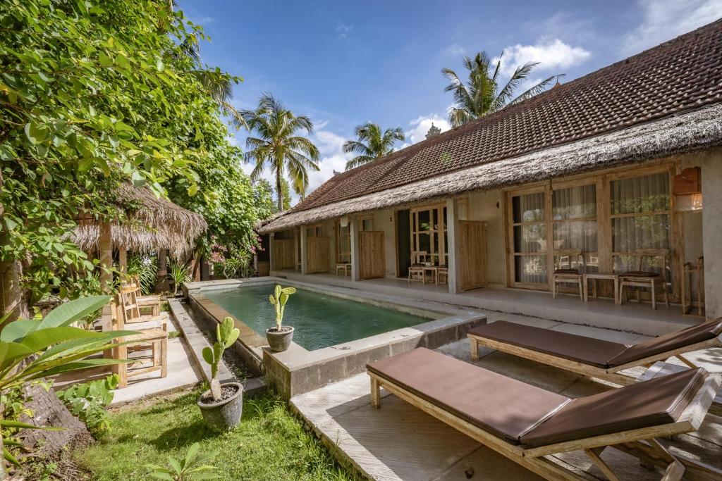 a villa with a swimming pool and a house at Golden Garuda Cottages at Diamond Beach Hills in Nusa Penida