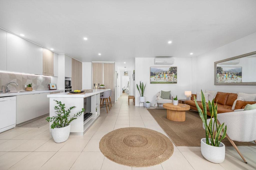 キングスクリフにあるLuxe on the Beach Coastal Elegance with Rooftopのソファとテーブルのあるキッチンとリビングルーム
