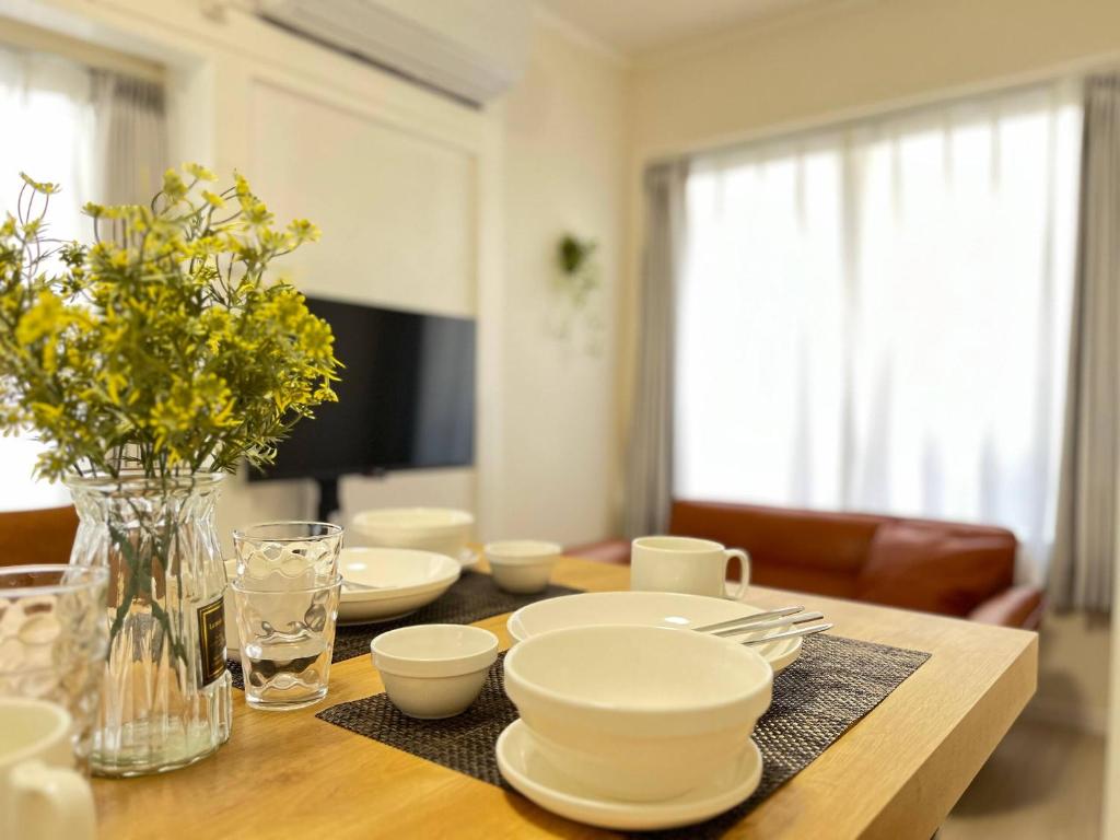 einen Esstisch mit weißen Gerichten und Blumen darauf in der Unterkunft Higashi tateishi Kodate HTI1 in Tokio
