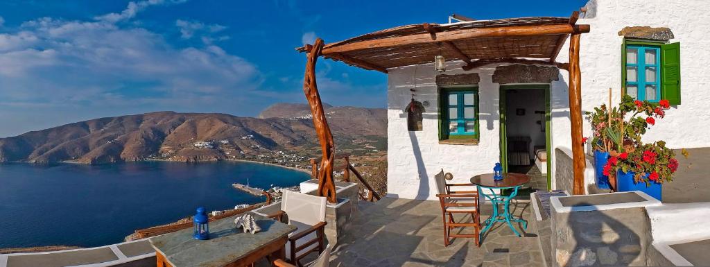 a house with a balcony with a view of the water at Pano Gitonia in Aegiali