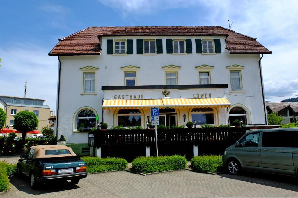 ein weißes Haus mit einem davor geparkt in der Unterkunft Hotel Löwen in Kirchzarten