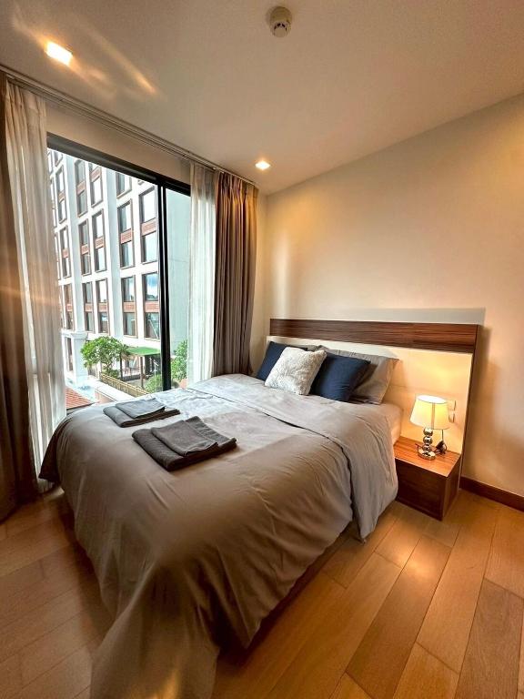 a bedroom with a large bed with a large window at The Astra Condo, Downtown in Chiang Mai