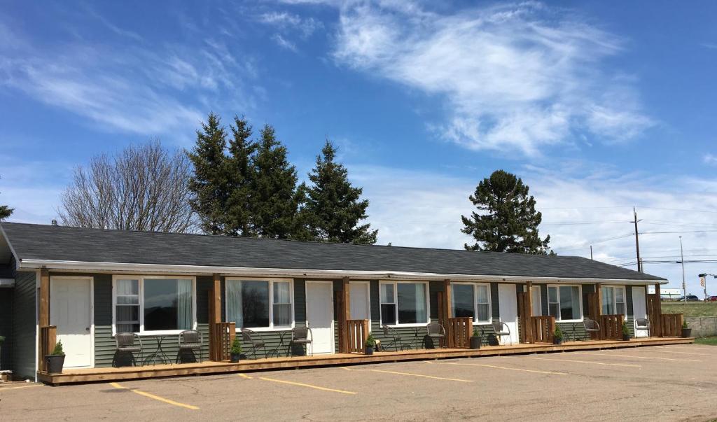 un edificio con bancos en un aparcamiento en Royalty Maples Cottages and Motel, en Charlottetown