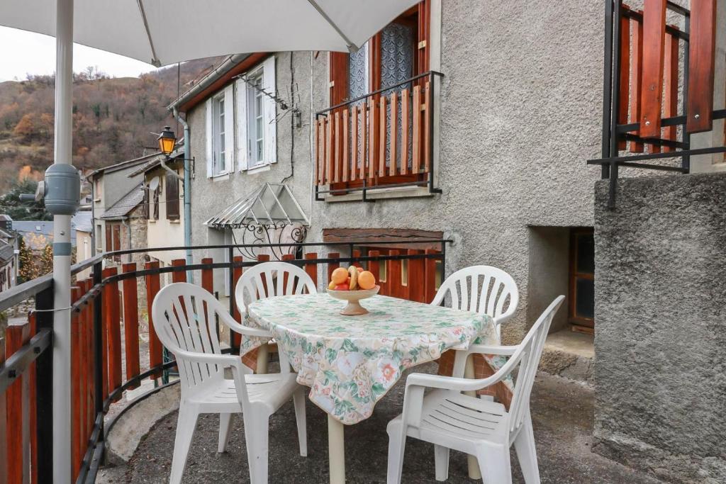 een tafel en stoelen op een balkon met een parasol bij Au cabanous in Boutx