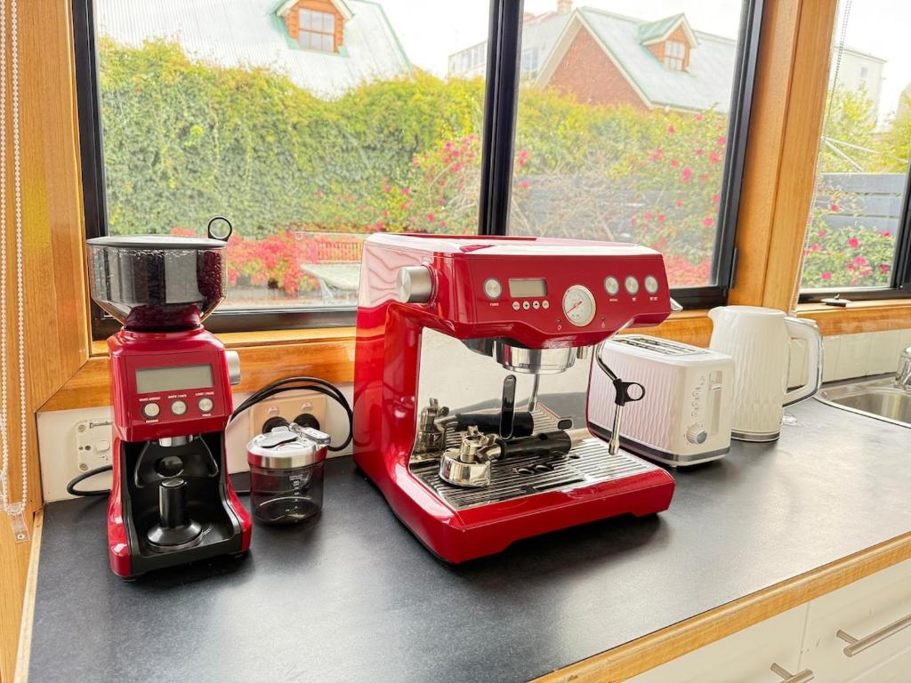 un mixeur rouge posé sur un comptoir à côté d'une fenêtre dans l'établissement Central Sandy Bay Retreat, à Sandy Bay