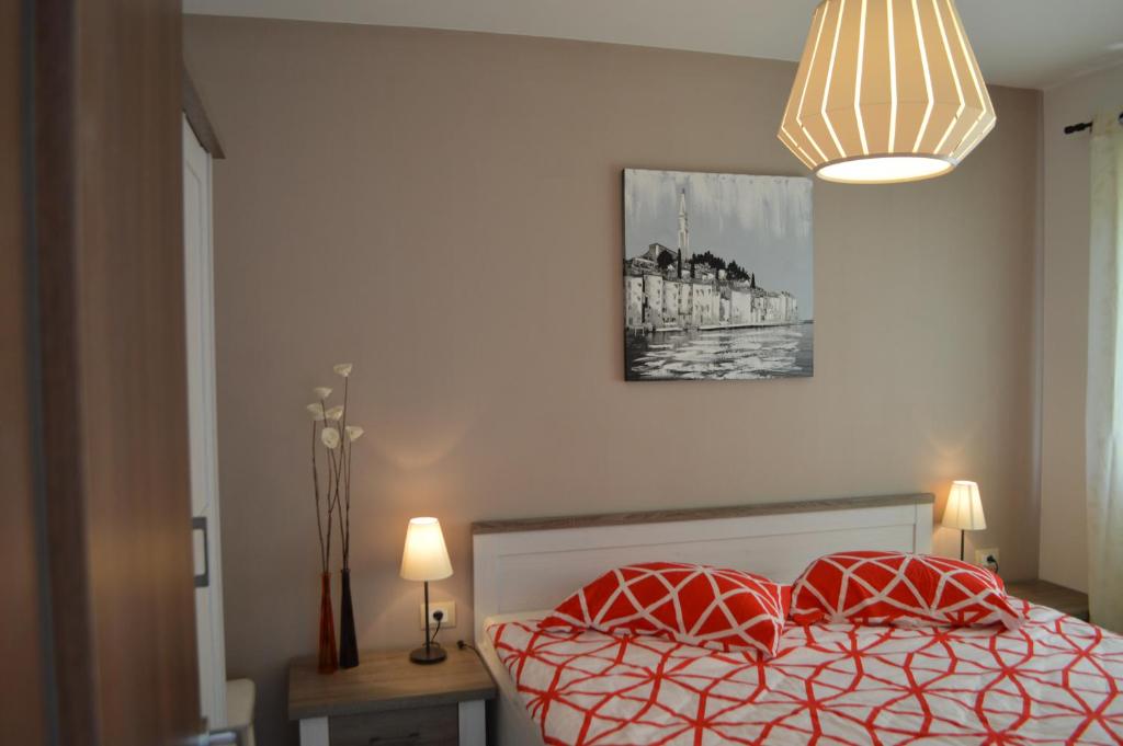 a bedroom with a bed with two red pillows at Apartment Bozac in Rovinj