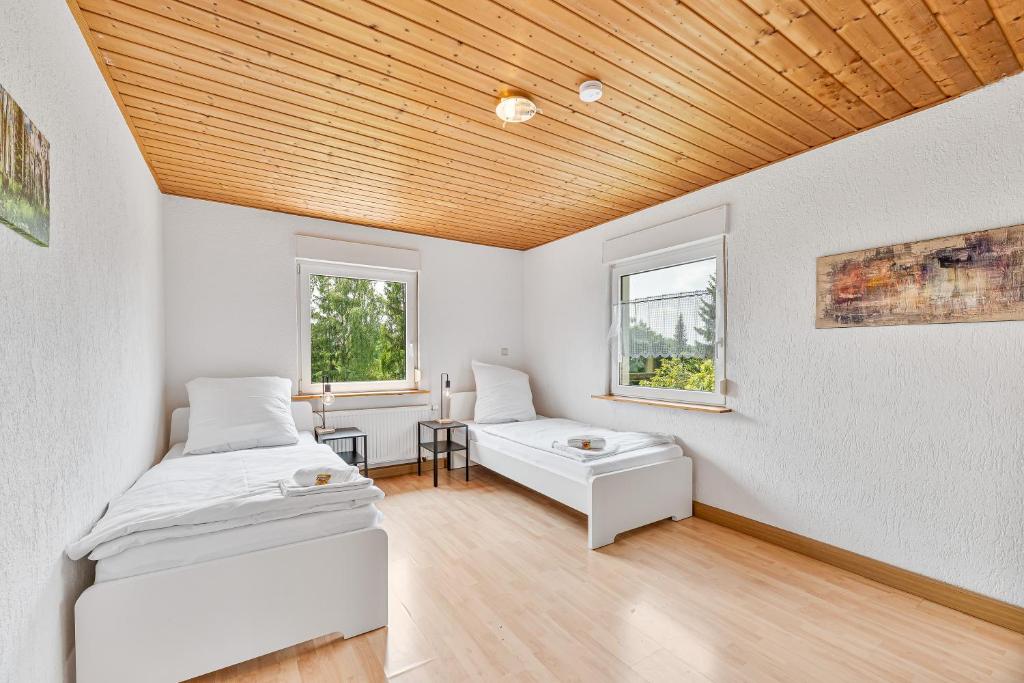 a bedroom with two beds and a wooden ceiling at GÜNSTIGE Wohnungen für Monteure in Suppingen-Laichingen Ulm,Neu-Ulm,TV,Wifi,Parking in Laichingen