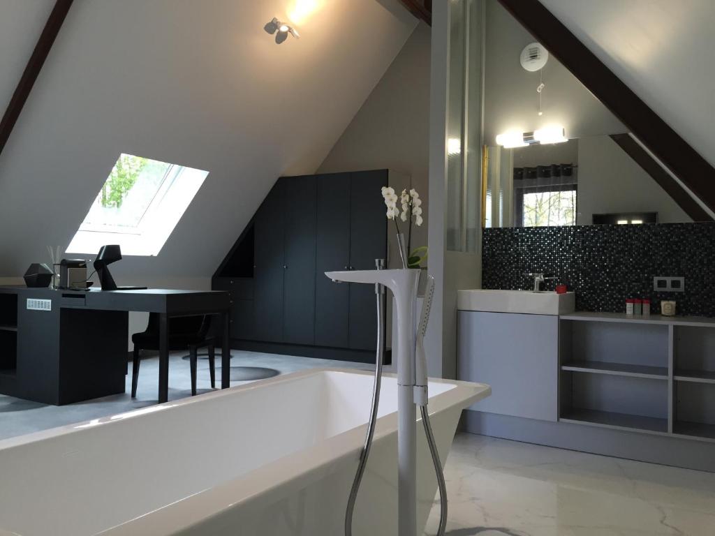 a bathroom with a bath tub and a table at Le Domaine des Loups in Souchez