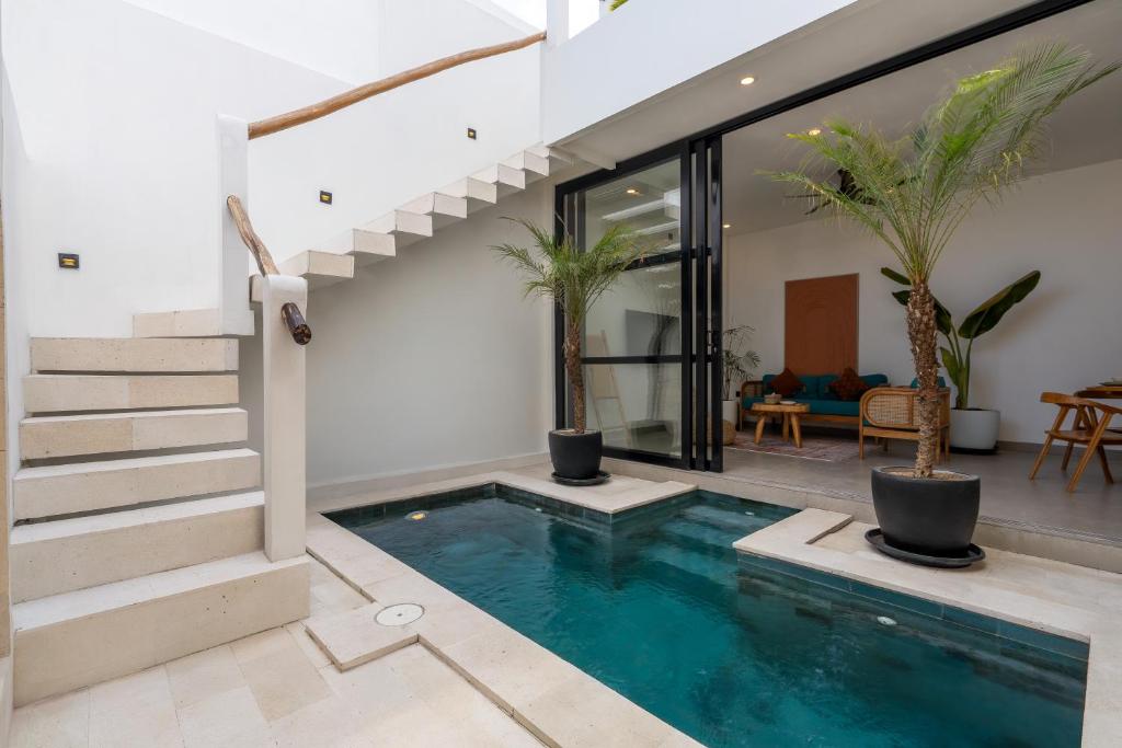 a house with a swimming pool and stairs at Enaya Villa by Betterplace in Tumbak Bayuh