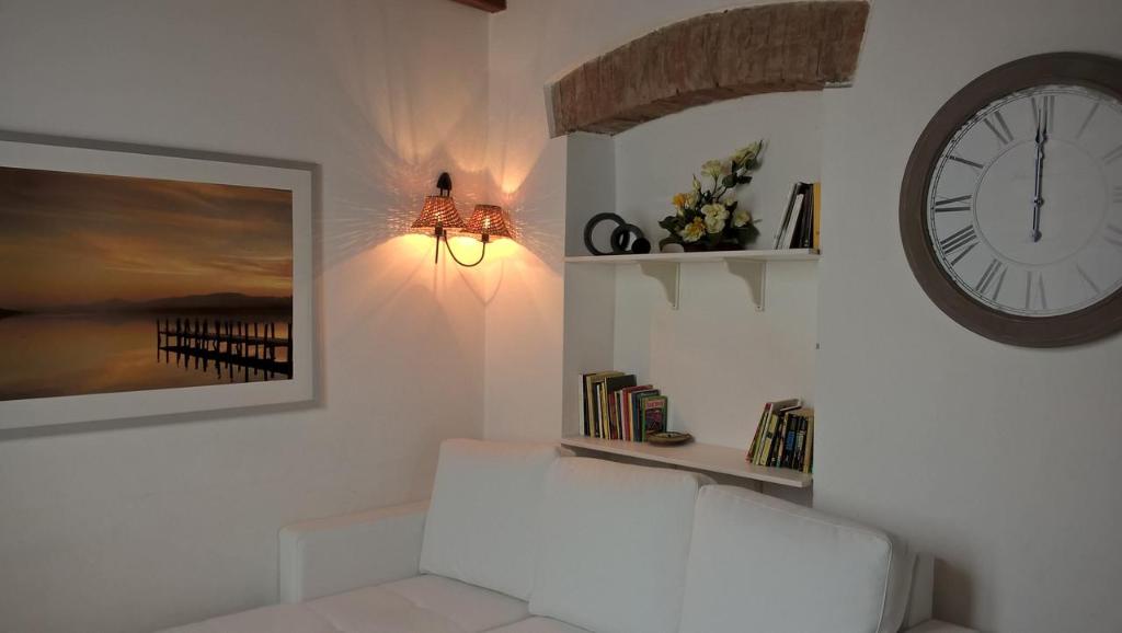 salon z zegarem i białą kanapą w obiekcie nel cuore di sestri w mieście Sestri Levante