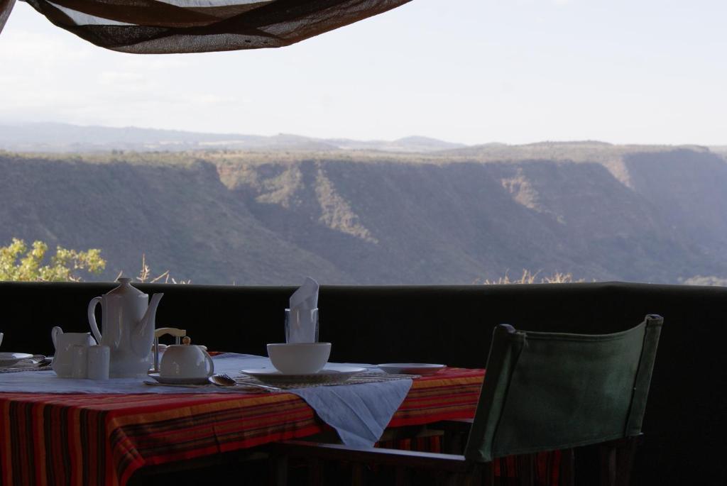 a dining table with a view of the mountains at African Sunrise Lodge and Campsite in Mto wa Mbu